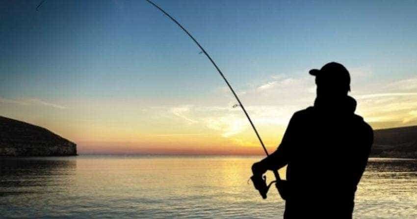 Bărbat la pescuit noaptea