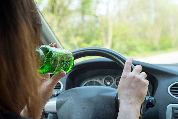 picture of woman drinking alcohol in the car.